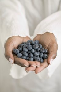 Woman's hands holding blueberries